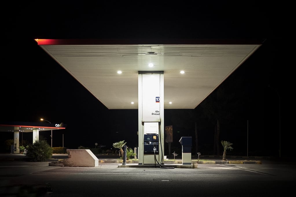 Fotografare i luoghi vuoti: distributore di benzina illuminato di notte, piazzale deserto.