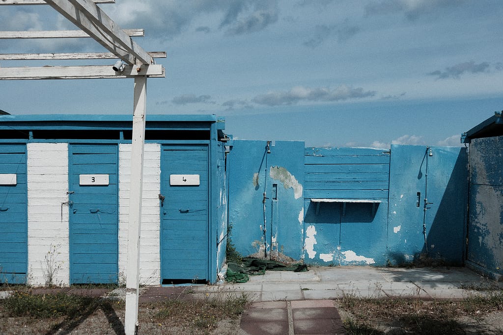 Cabine blu chiuse con i numeri 3 e 4 e docce scrostate