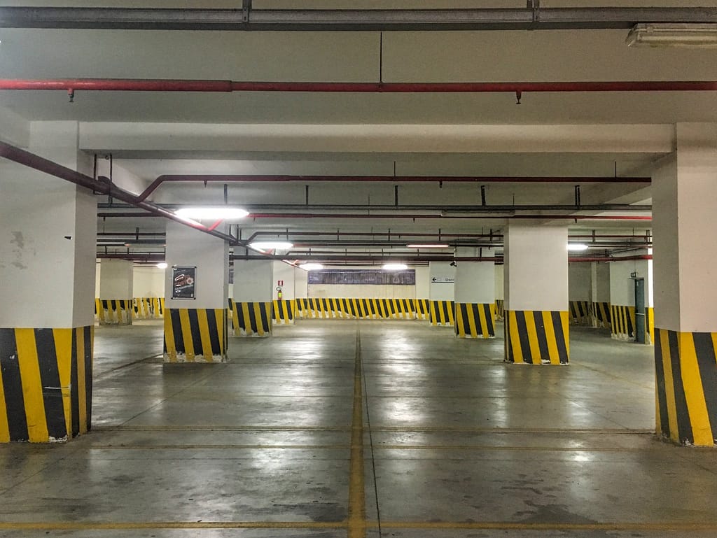 Parcheggio sotterraneo vuoto con pilastri a strisce gialle e nere, Messina
