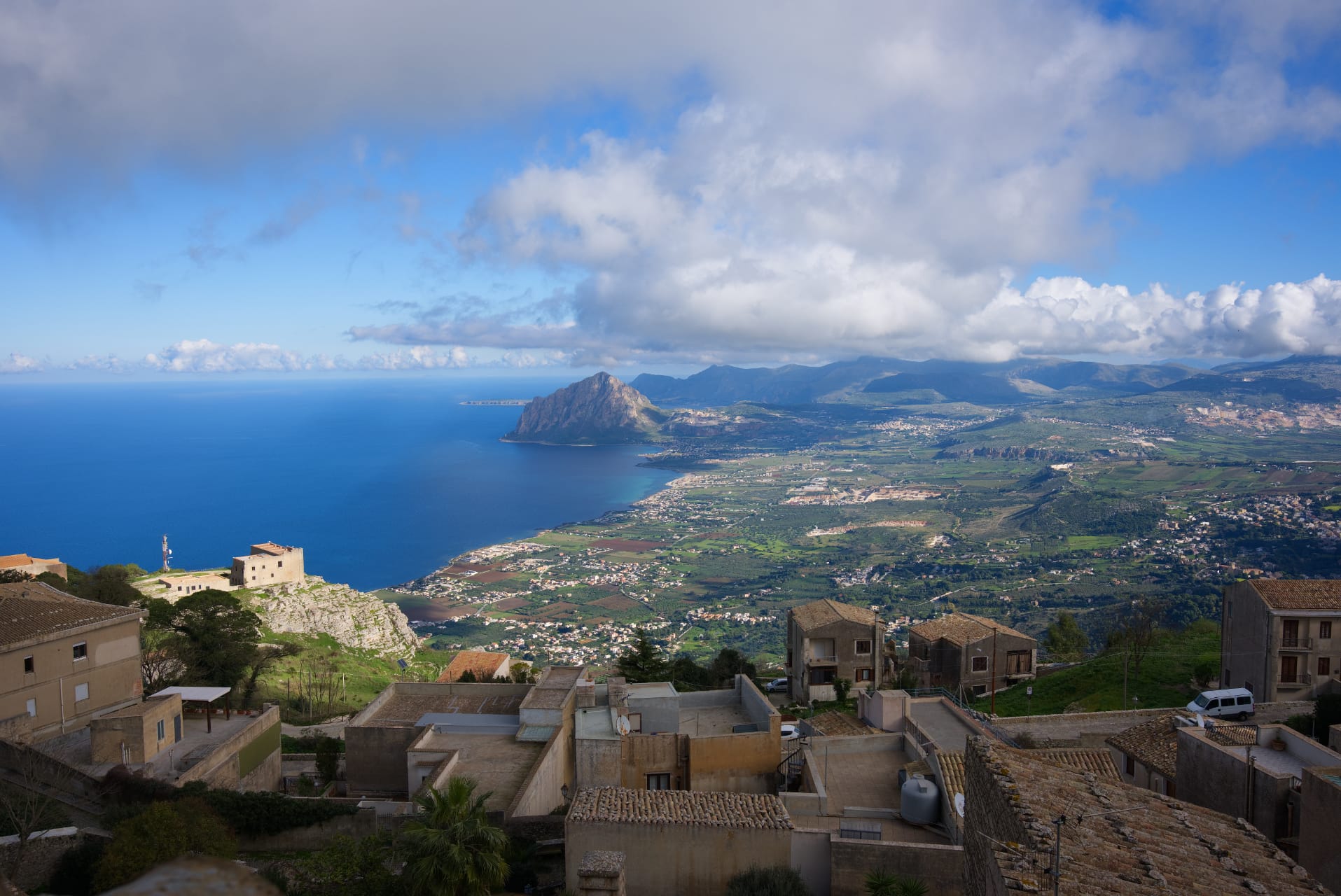 Vista da Erice sul golfo con Monte Cofano, le campagne e i tetti del paese in primo piano