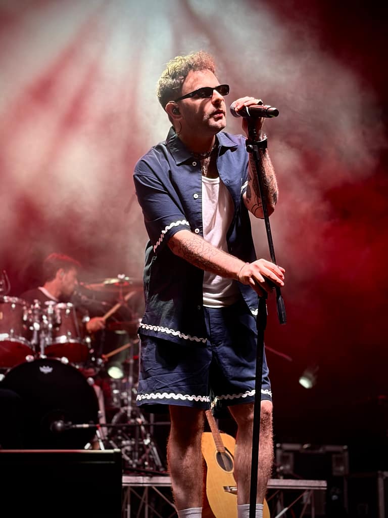 Cantante sul palco avvolto dal fumo e dalle luci rosse