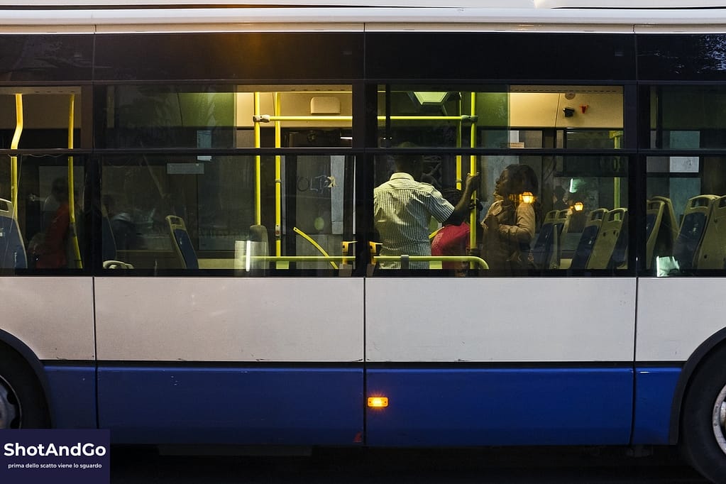 GUIDA 1 — Da dove Partire, vuoi davvero imparare a fotografare? Persone viste attraverso i finestrini di un autobus urbano al tramonto, scena di vita quotidiana che dimostra come ogni momento possa diventare fotografia.