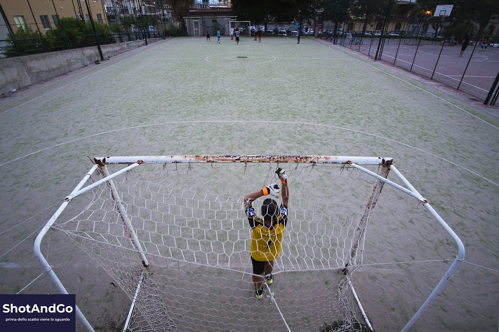 Bambino in porta visto dall’alto durante una partita, esempio di storytelling fotografico