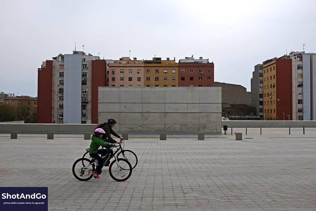 Ciclista attraversa un’ampia piazza urbana, ideale per comprendere il rapporto tra ISO, diaframma e tempo di scatto nella fotografia.