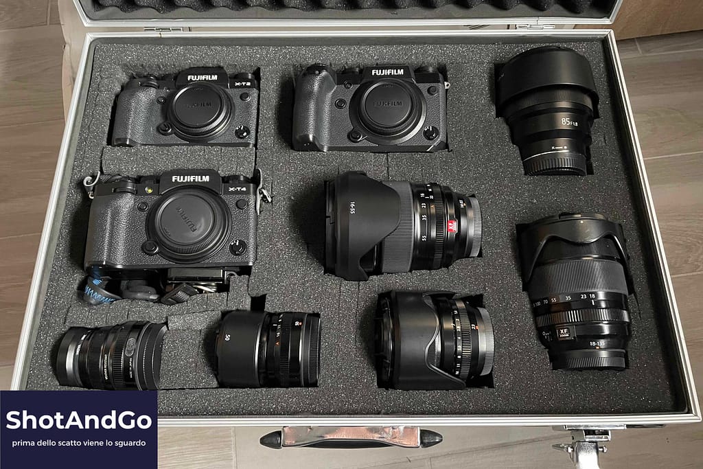 La verità sull’attrezzatura che serve davvero (e quella che puoi ignorare) Corredo fotografico composto da fotocamere mirrorless e obiettivi disposto in una valigia protettiva, simbolo dell’attrezzatura fotografica e delle scelte consapevoli.